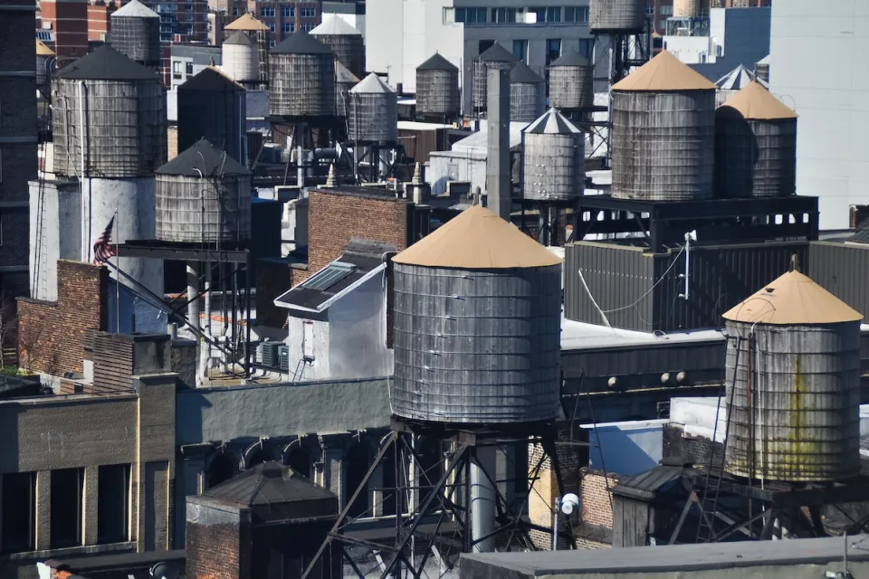 Old water towers on dense New York City rooftops.